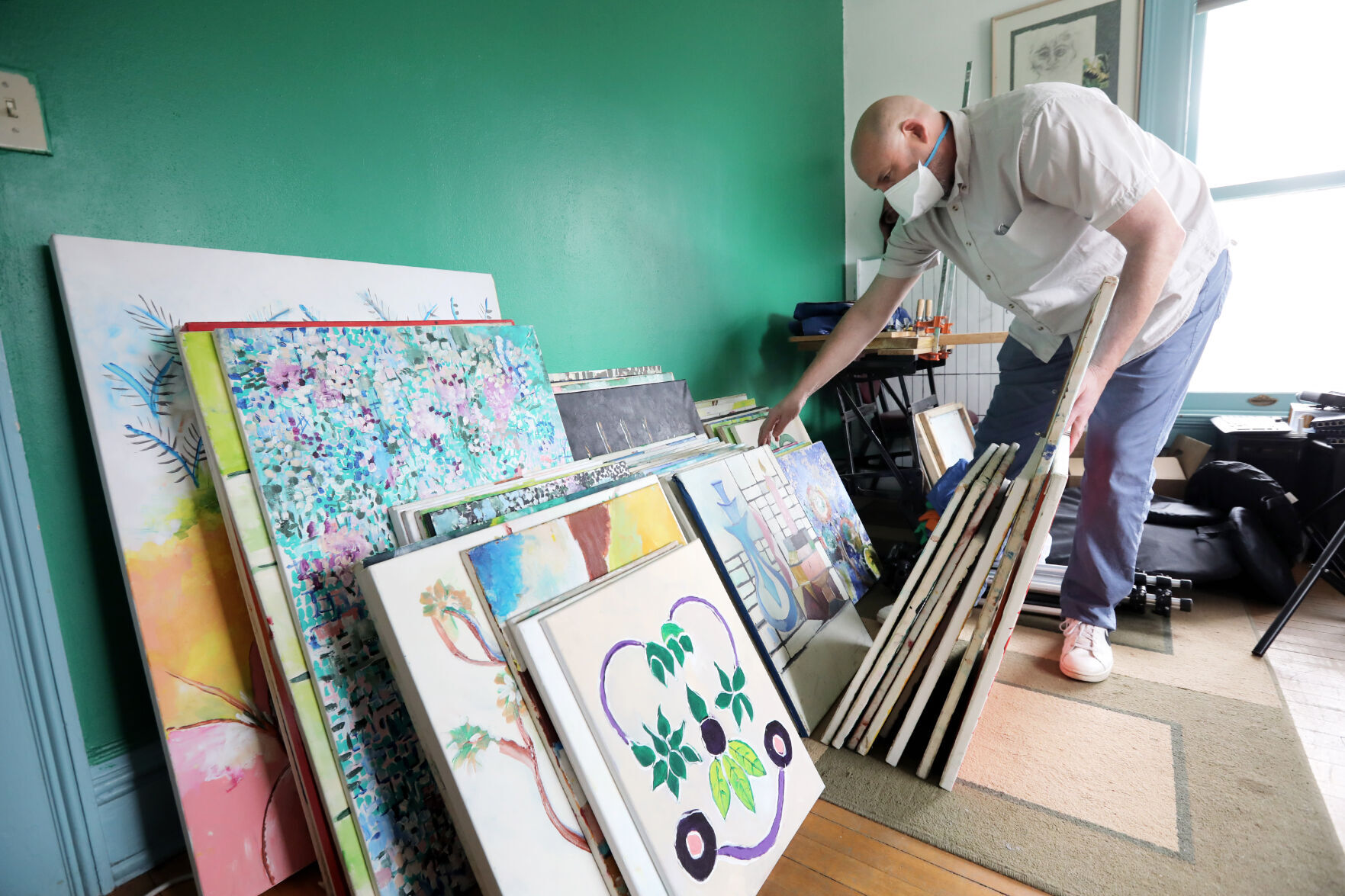 Brad Schlough looking through paintings